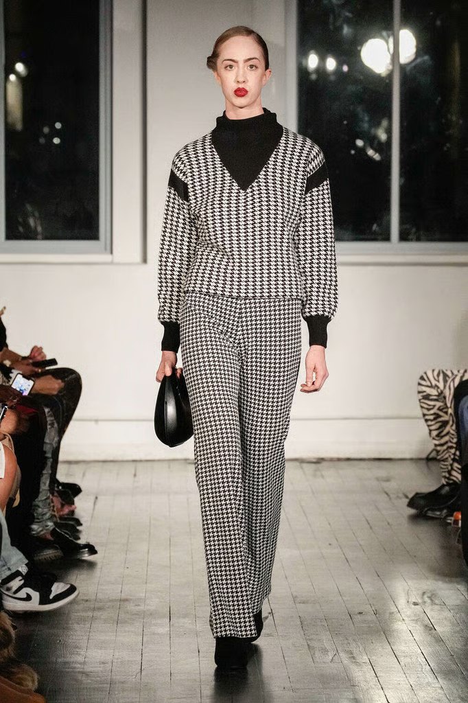 Kristin walking the runway in a black and white houndstooth sweater and trousers